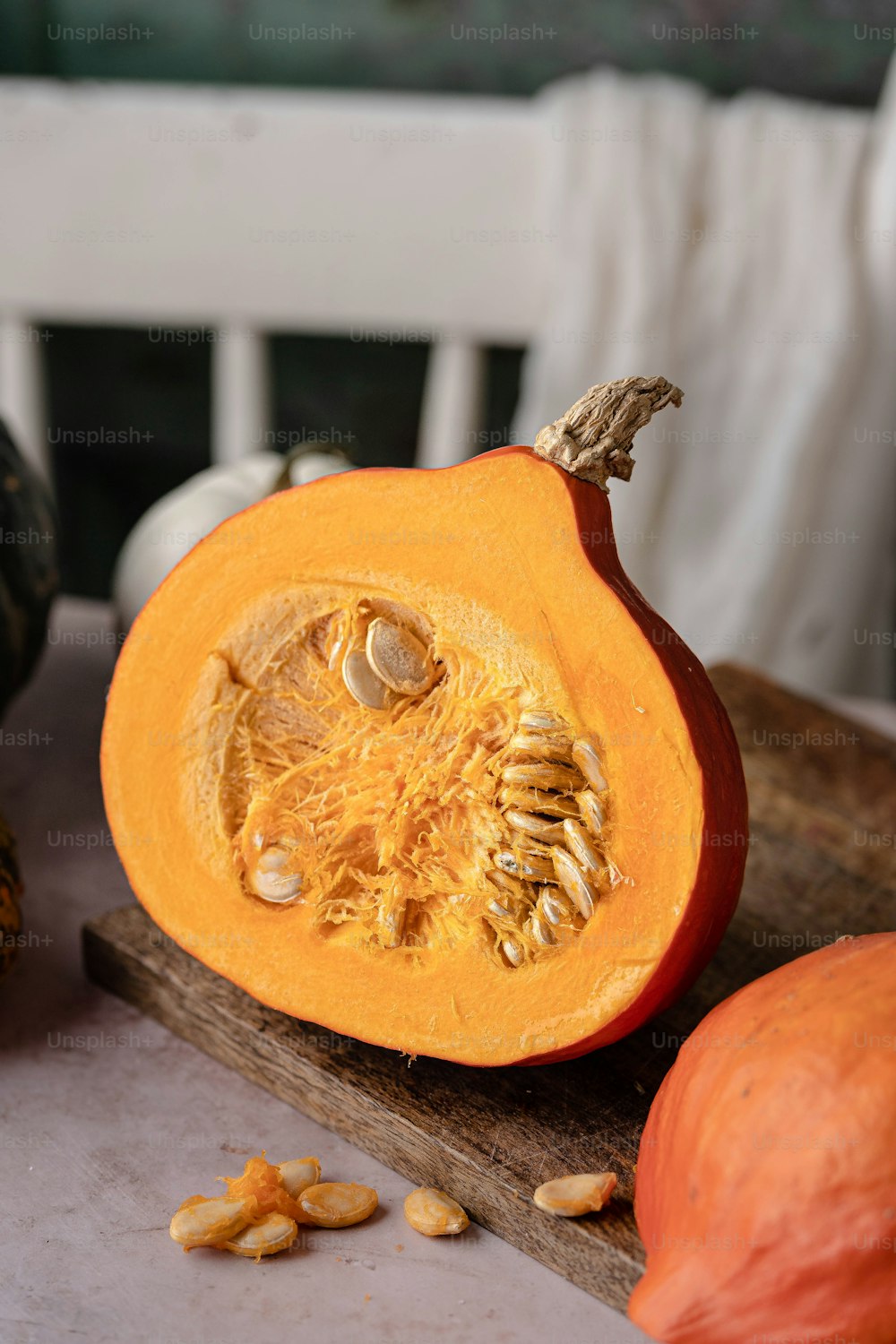 a pumpkin cut in half sitting on a cutting board