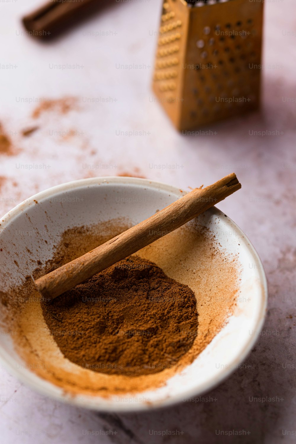 a bowl of cinnamon powder with a cinnamon stick sticking out of it