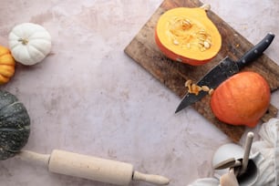 a cutting board with a knife and pumpkins on it