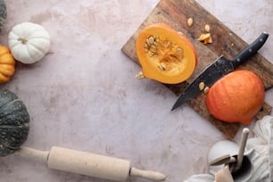 a cutting board with a knife and some pumpkins