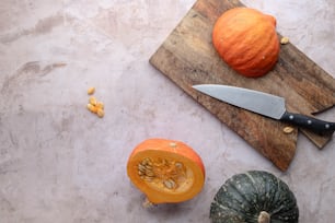 a cutting board with a knife and some pumpkins
