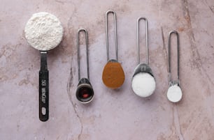 Una variedad de cucharas medidoras y cucharas medidoras en una mesa
