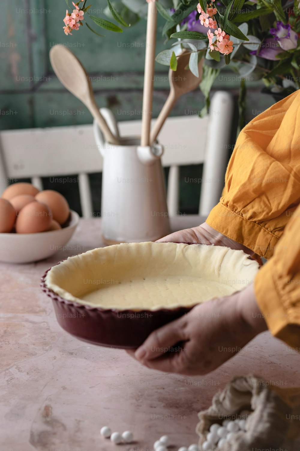 a person holding a pie pan on a table
