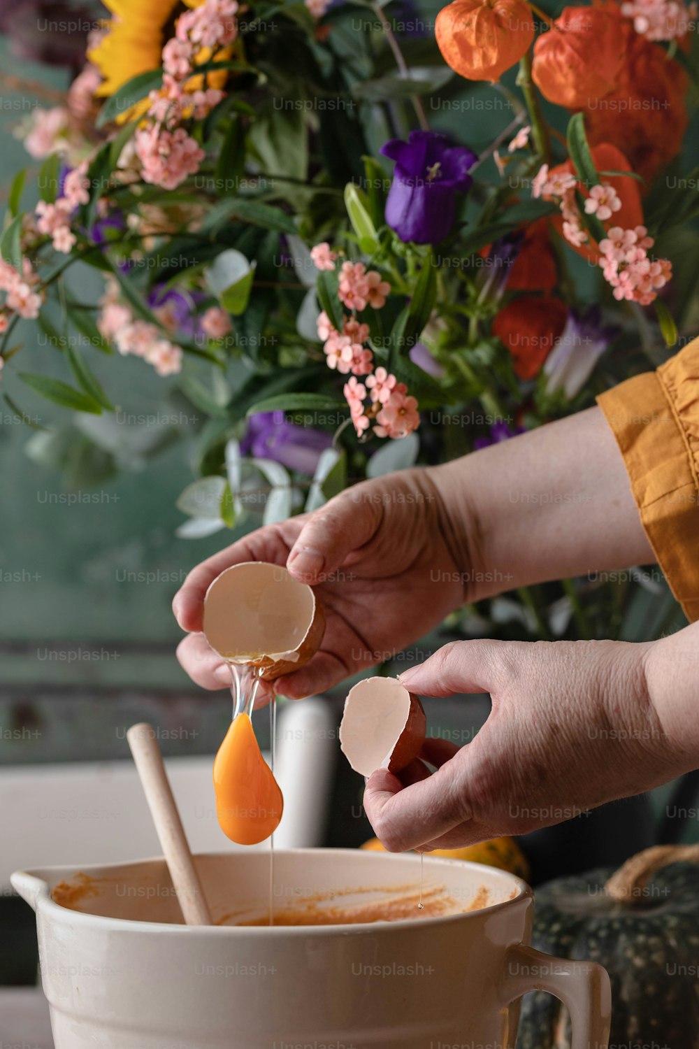 a person pouring liquid into a bowl of food