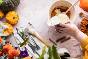 a person holding a spoon over a bowl of food