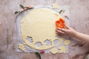 a person is decorating a cake with orange icing