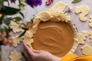 a person holding a pie with a lot of decorations around it