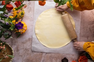 a person rolling dough on a piece of paper