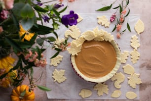 a pie sitting on top of a table next to flowers