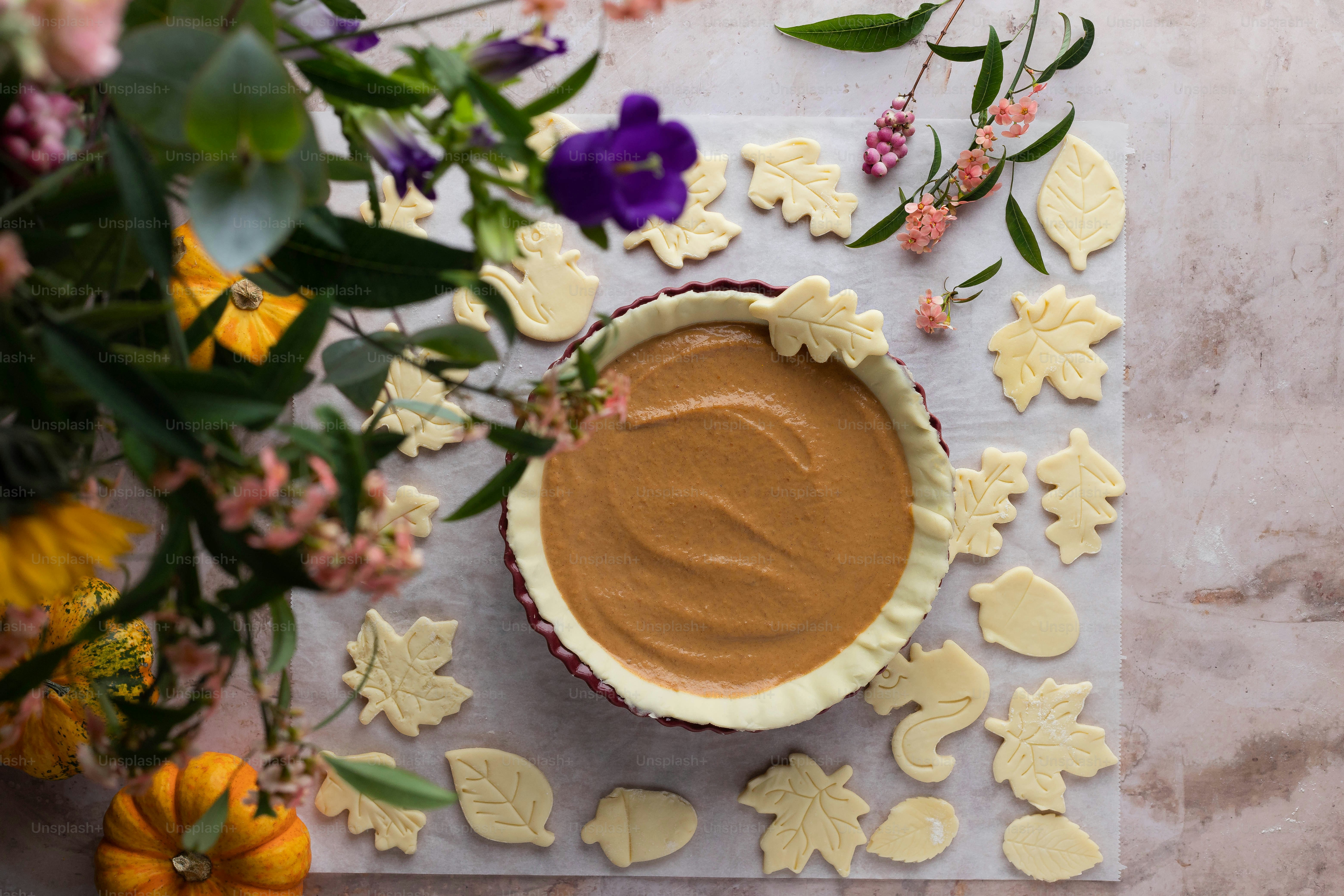 a pie sitting on top of a table next to flowers