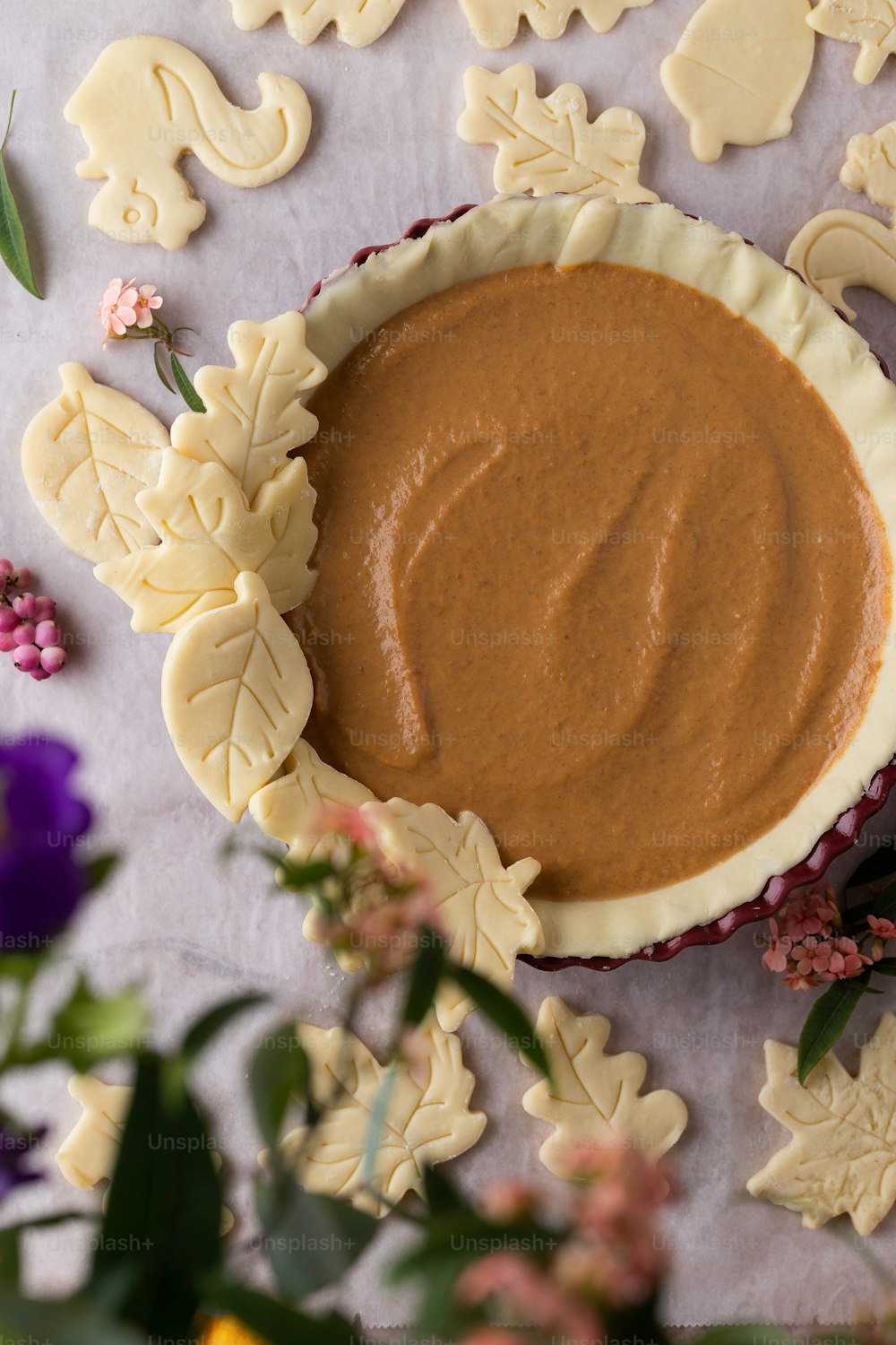 a bowl of peanut butter surrounded by cookies and flowers