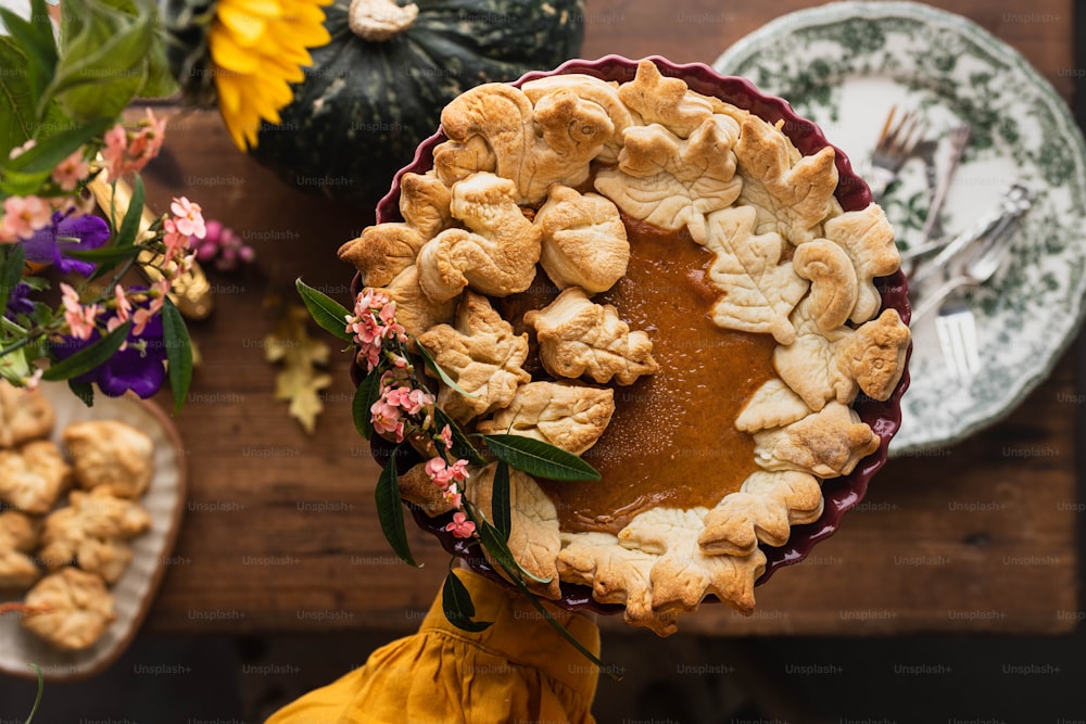 a pie on a table with flowers and plates
