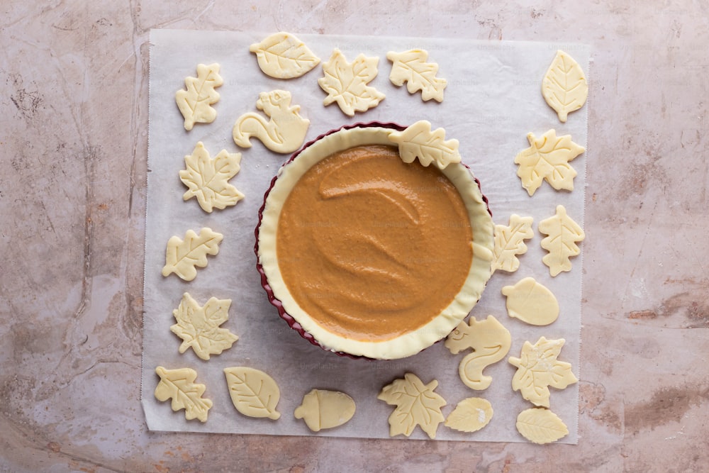 a bowl of peanut butter surrounded by cookies