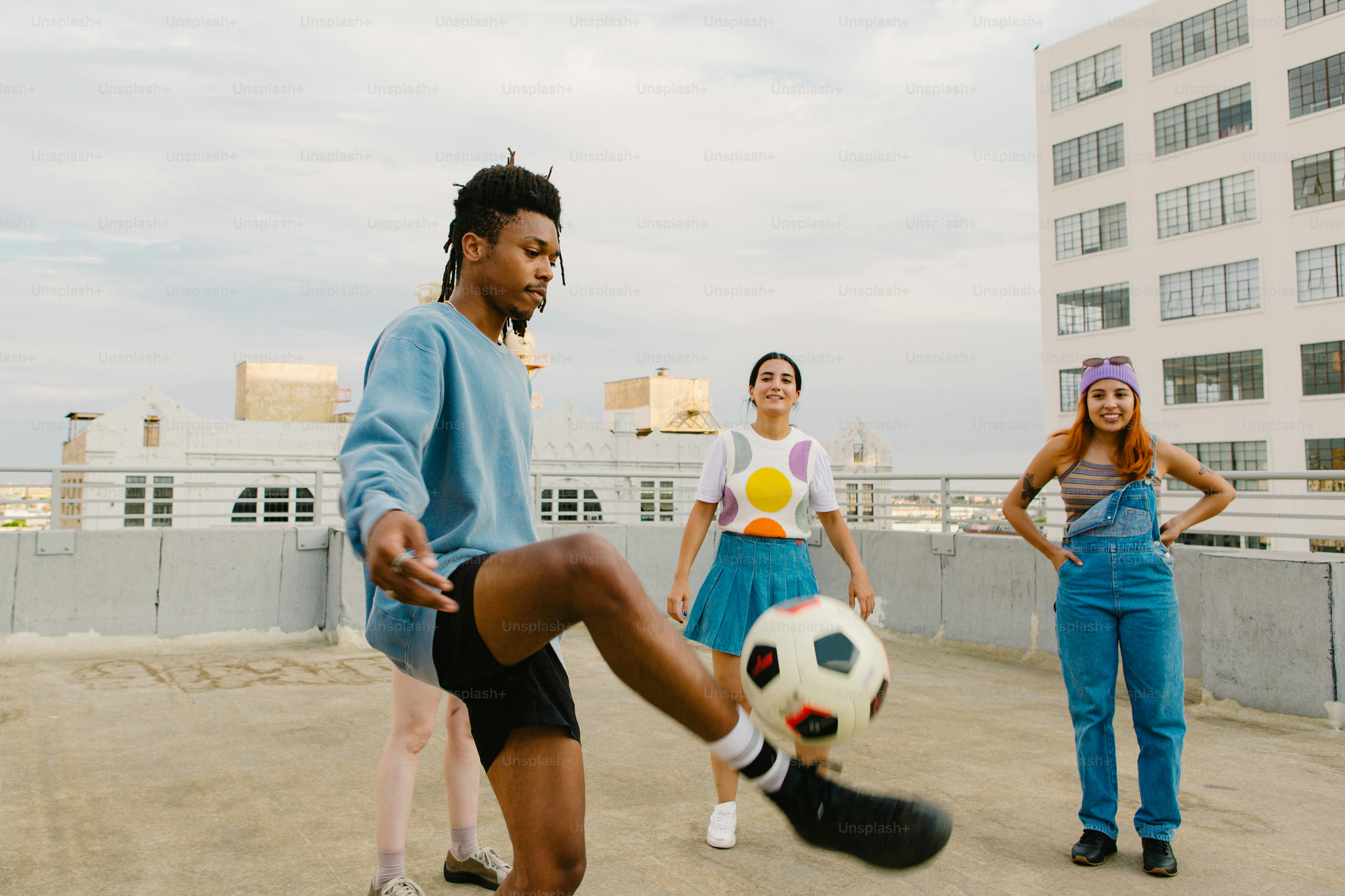 a man kicking a soccer ball on top of a roof