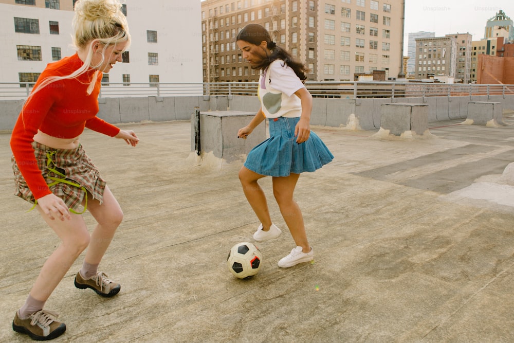 두 소녀가 축구공을 가지고 놀고 있다