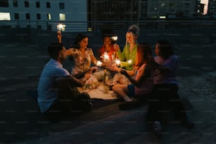 Eine Gruppe von Menschen, die um einen Tisch sitzen und Kerzen halten
