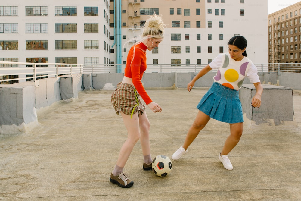 two girls are playing with a soccer ball