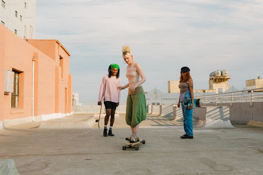 um grupo de três mulheres em pé uma ao lado da outra em um skate