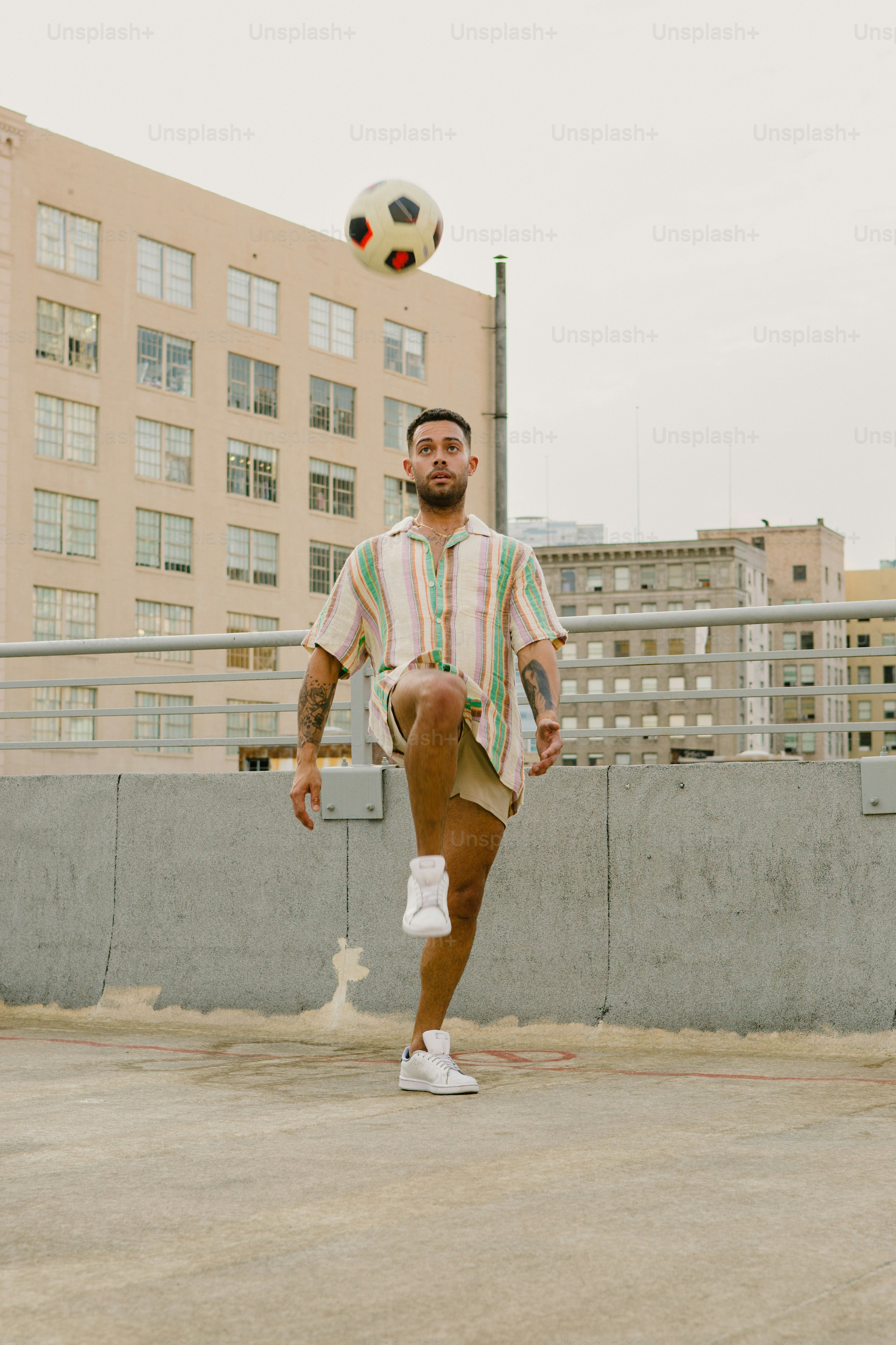 Un hombre con una pelota de fútbol en el aire