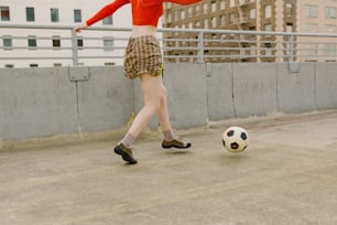 Eine Frau, die einen Fußball auf einem Dach kickt