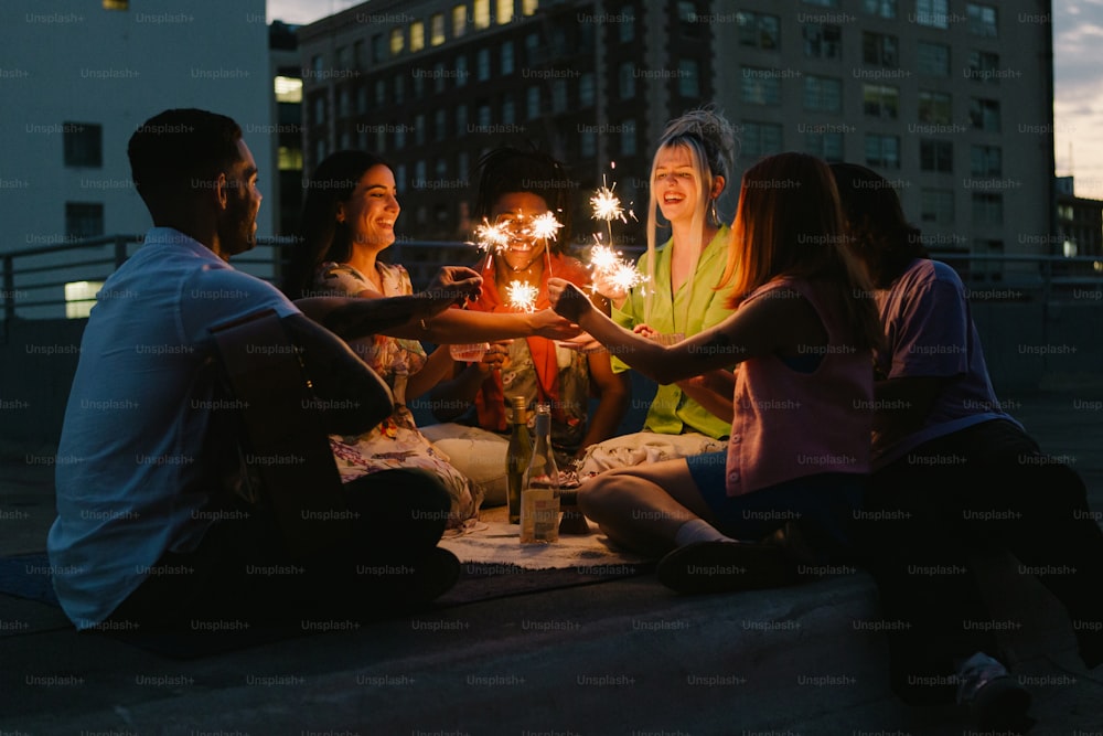 Un grupo de personas sentadas alrededor de una mesa sosteniendo bengalas