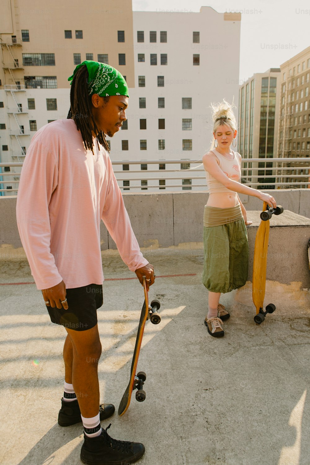 a man holding a skateboard next to a woman