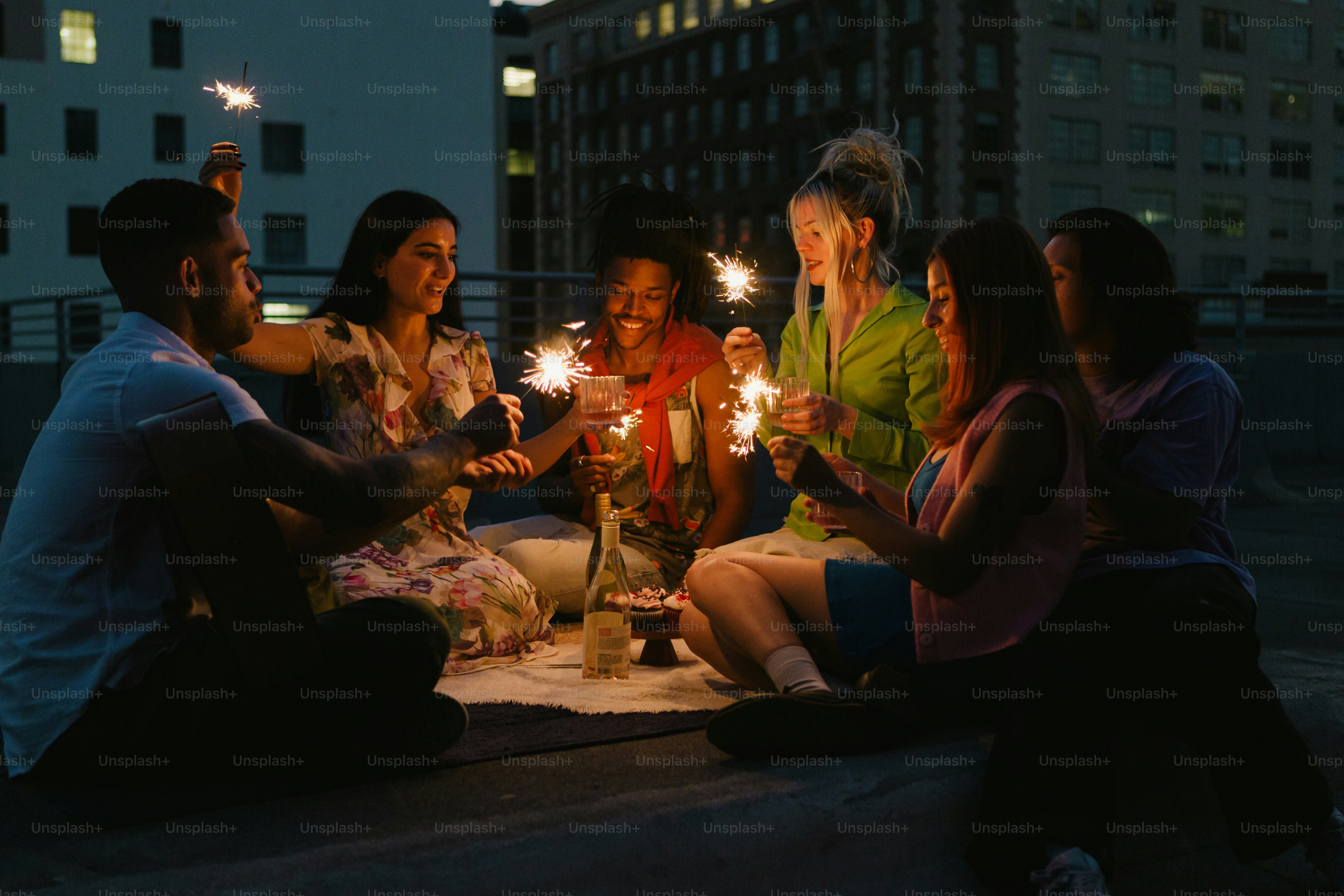 a group of people sitting around a table holding sparklers