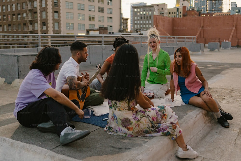 a group of people sitting on top of a cement slab