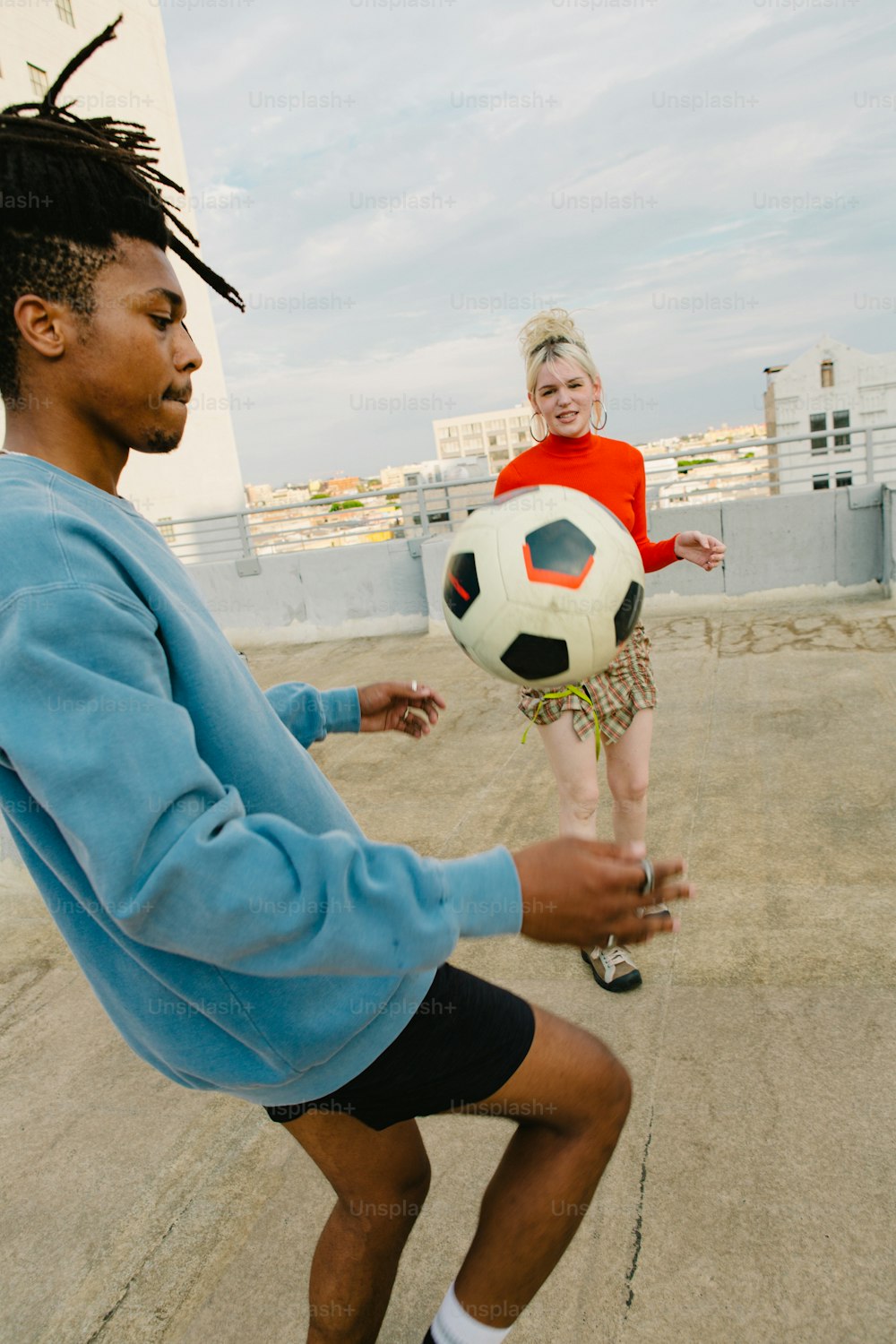 Un homme avec des dreadlocks jouant avec un ballon de football