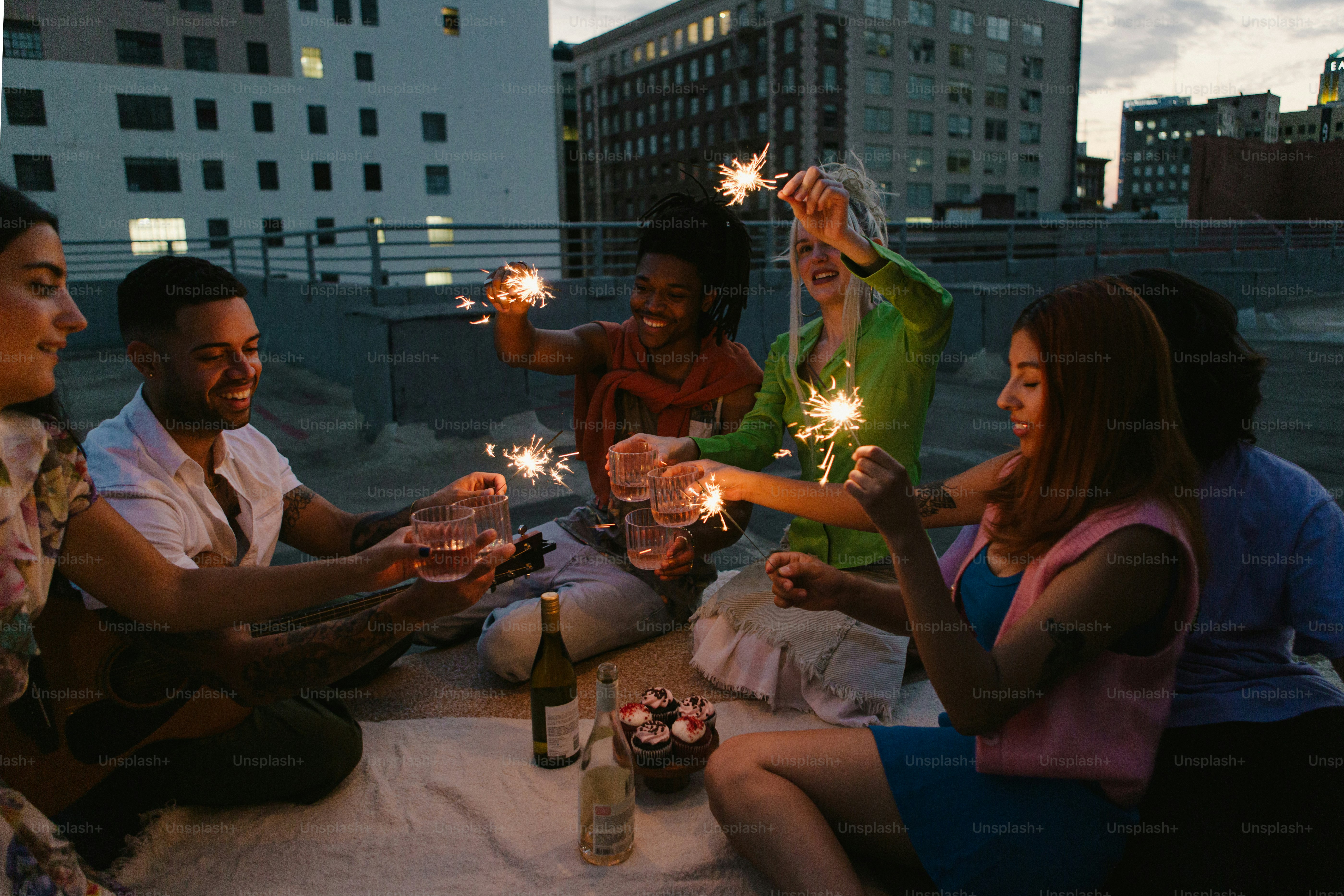 a group of people sitting around a table holding sparklers