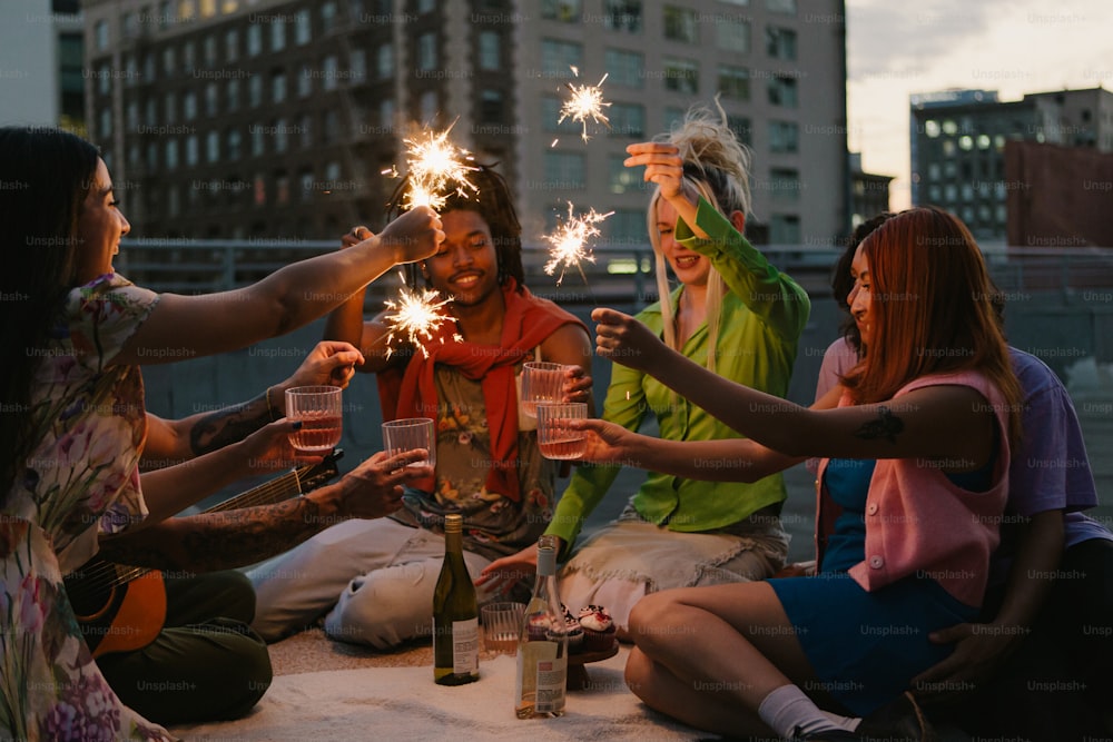 a group of people sitting around a table holding sparklers