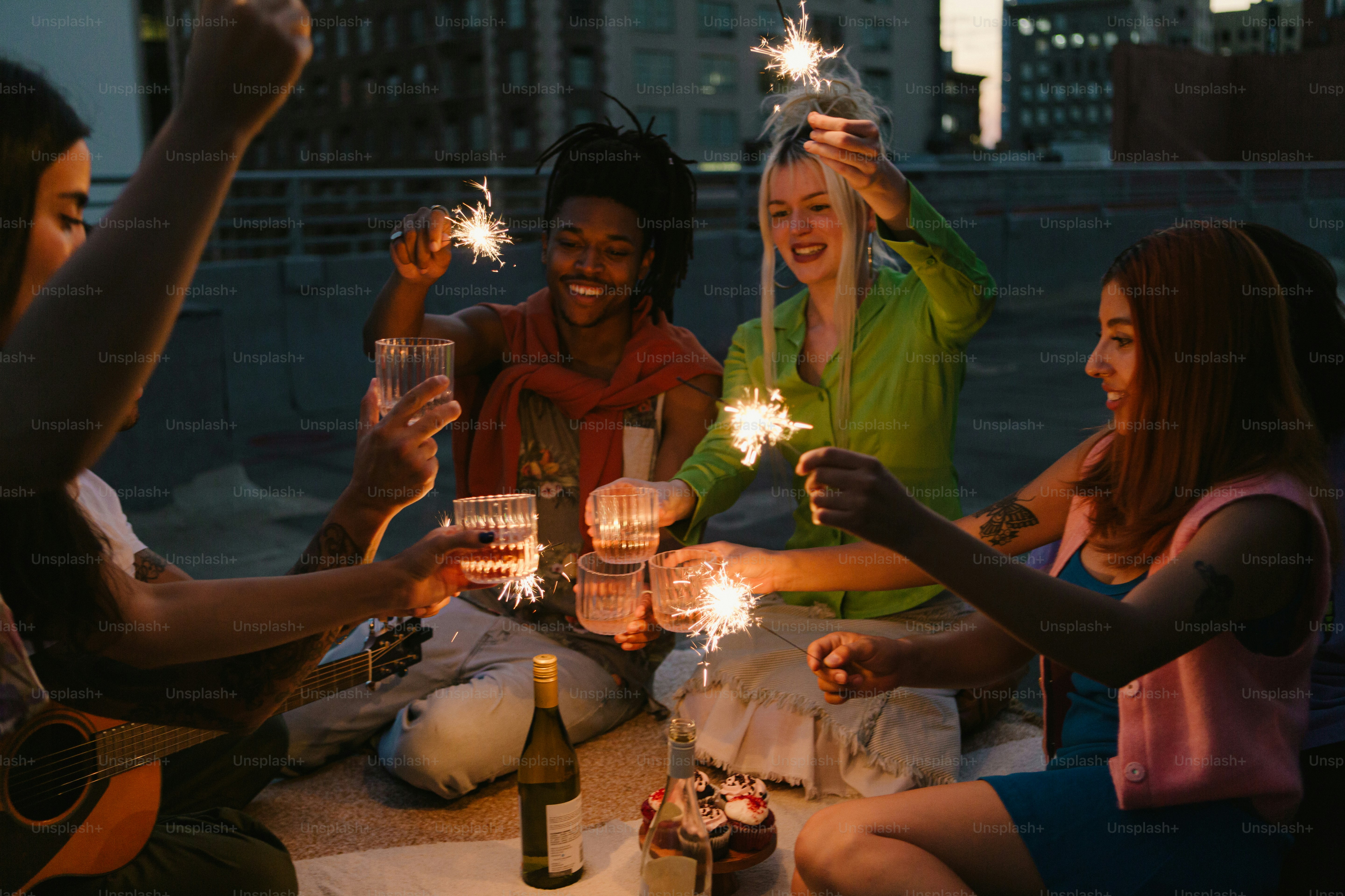 a group of people sitting around a table holding sparklers