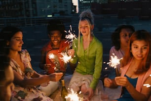 a group of women sitting around each other holding sparklers