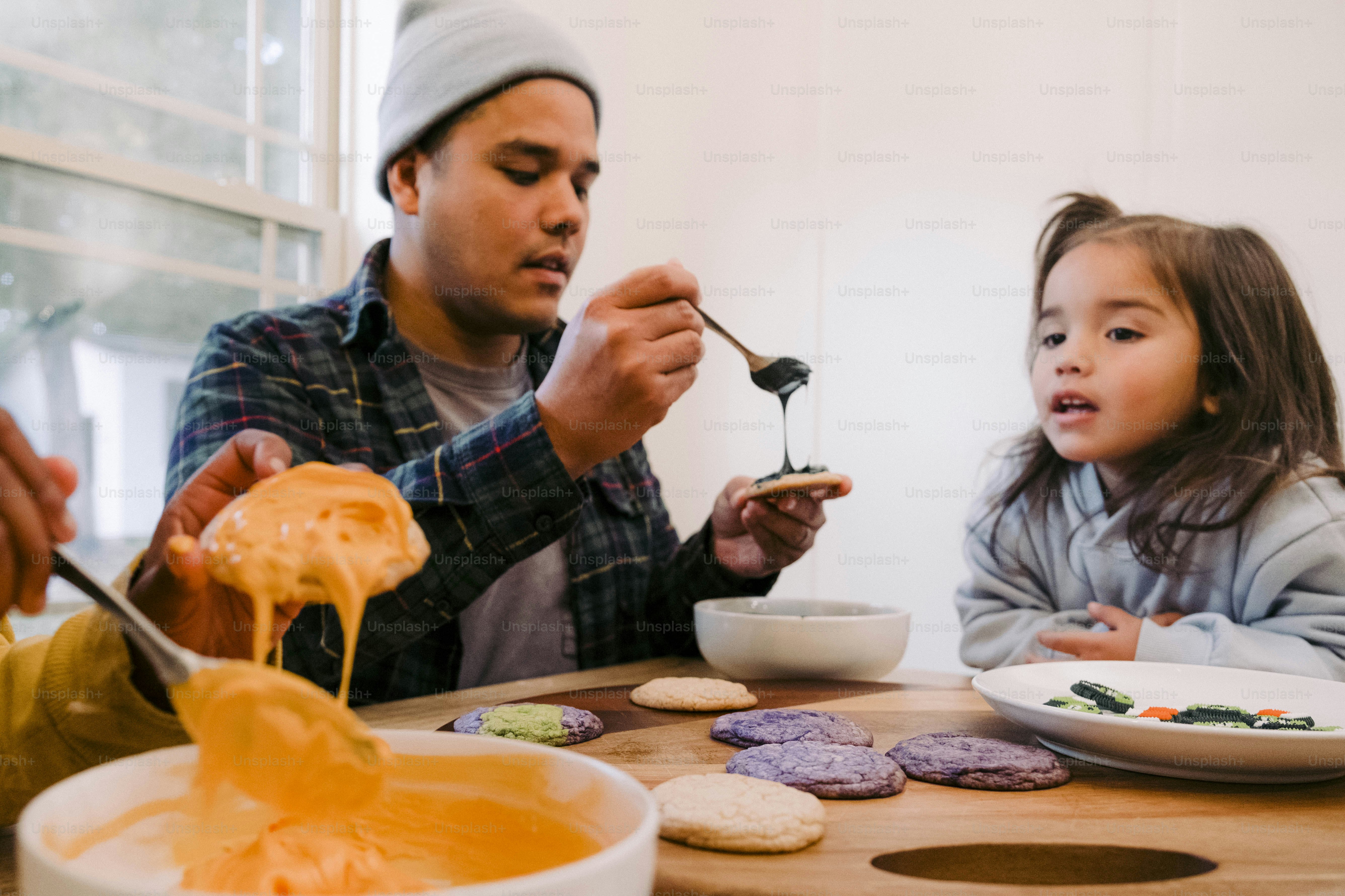 a man and a little girl sitting at a table eating
