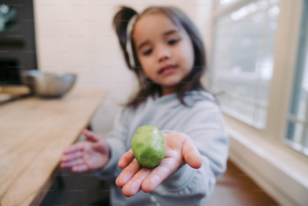 Ein kleines Mädchen, das einen grünen Apfel in der Hand hält