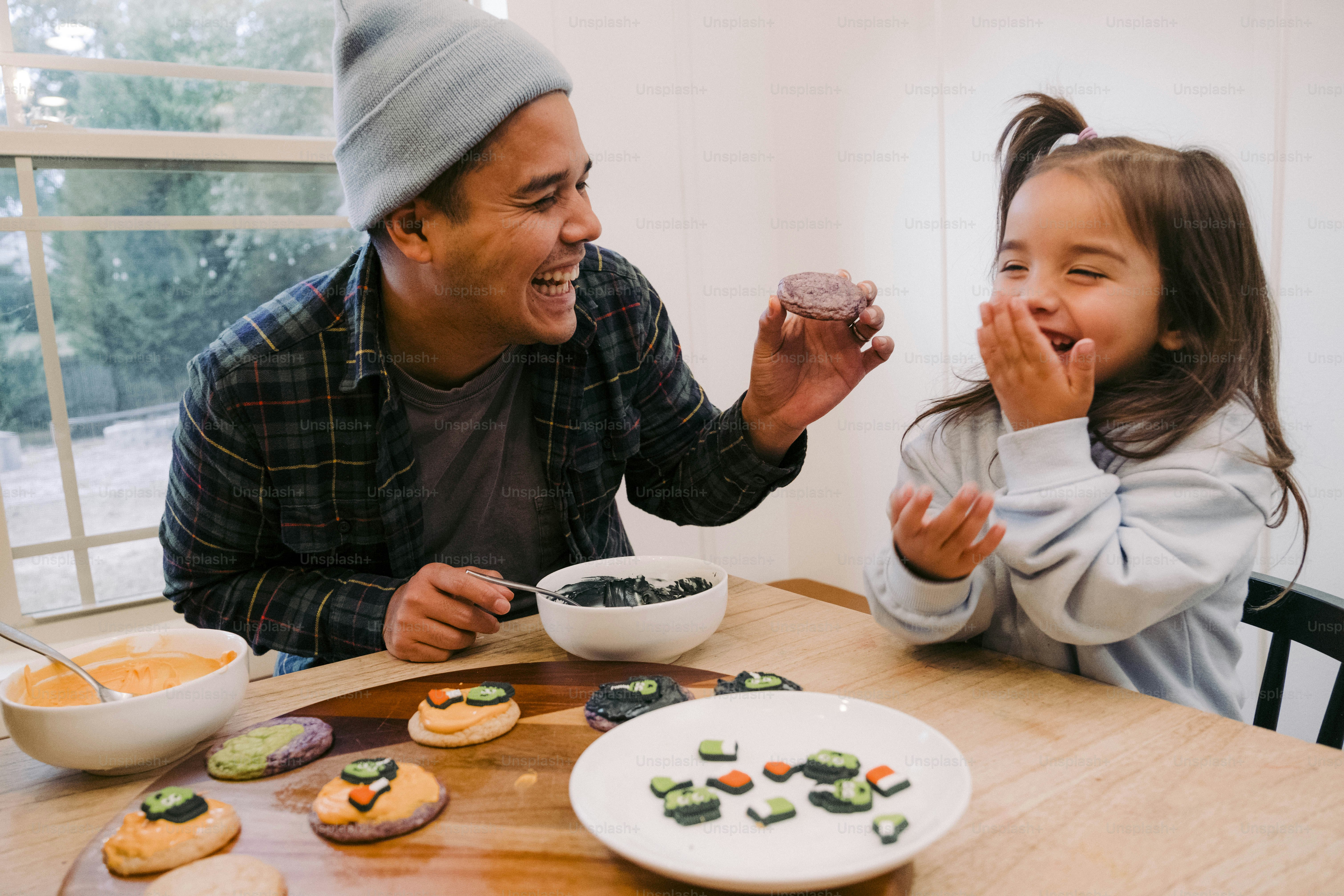 a man and a little girl sitting at a table eating food