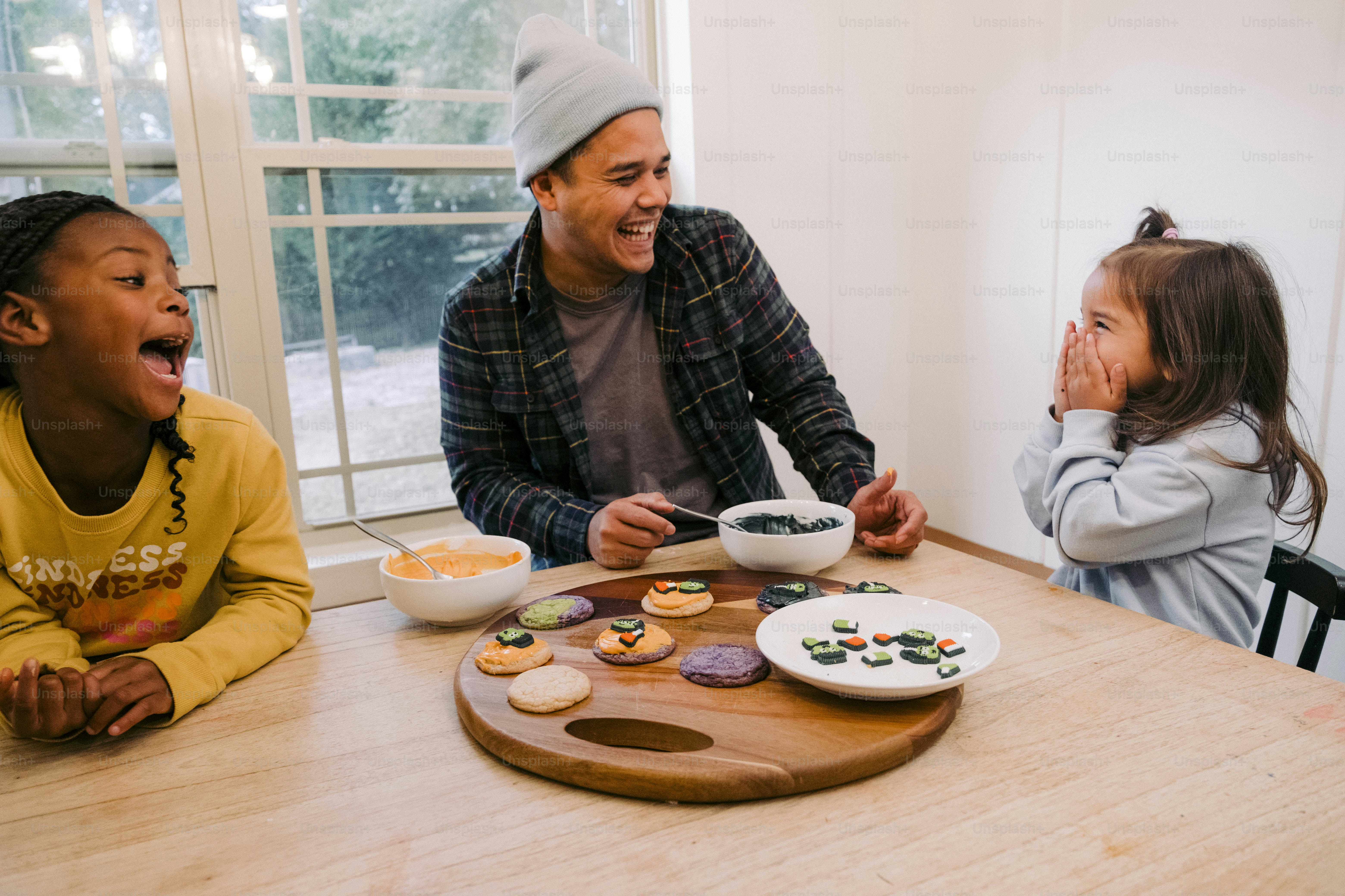 a man sitting at a table with two little girls