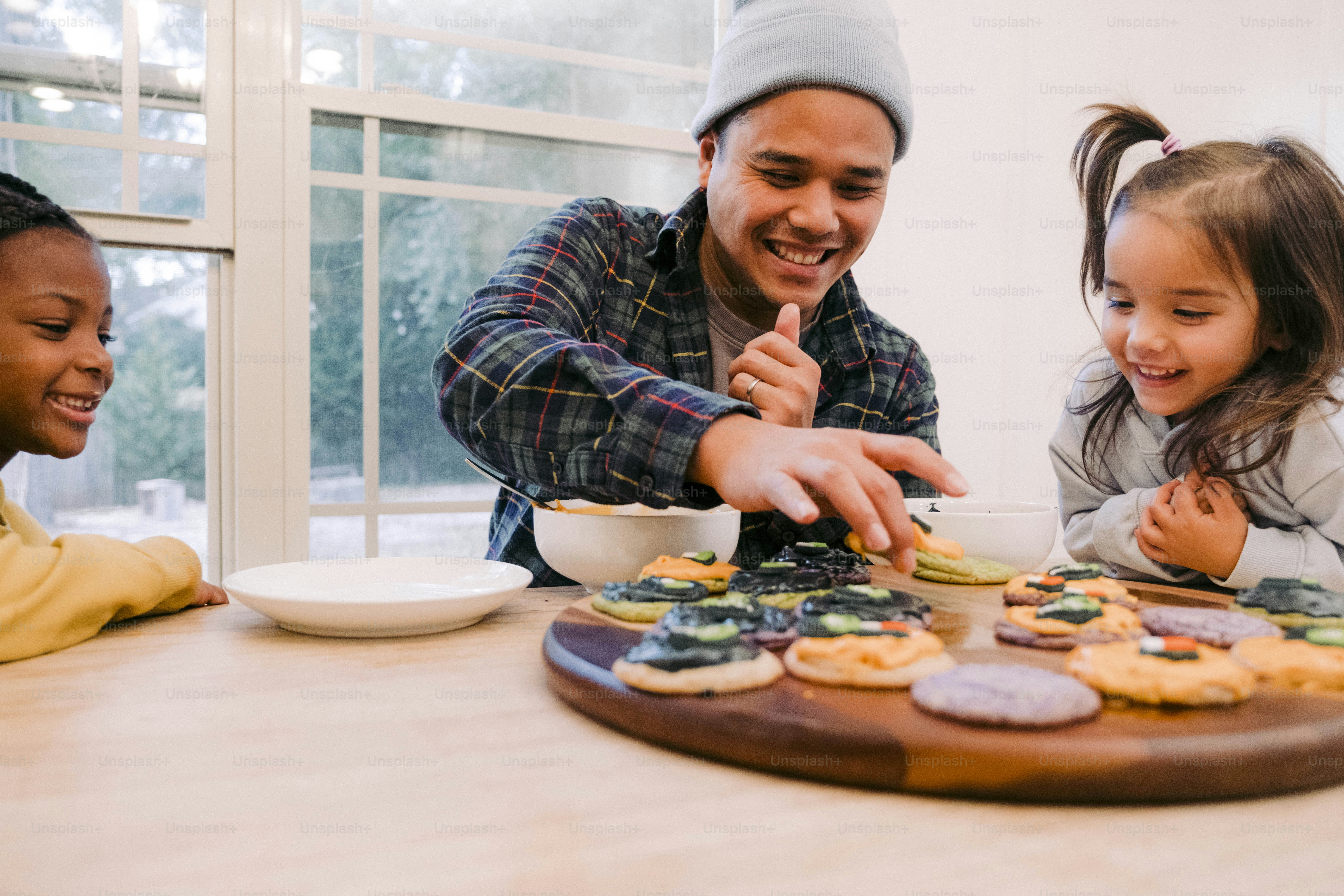 a man and two little girls are making cookies