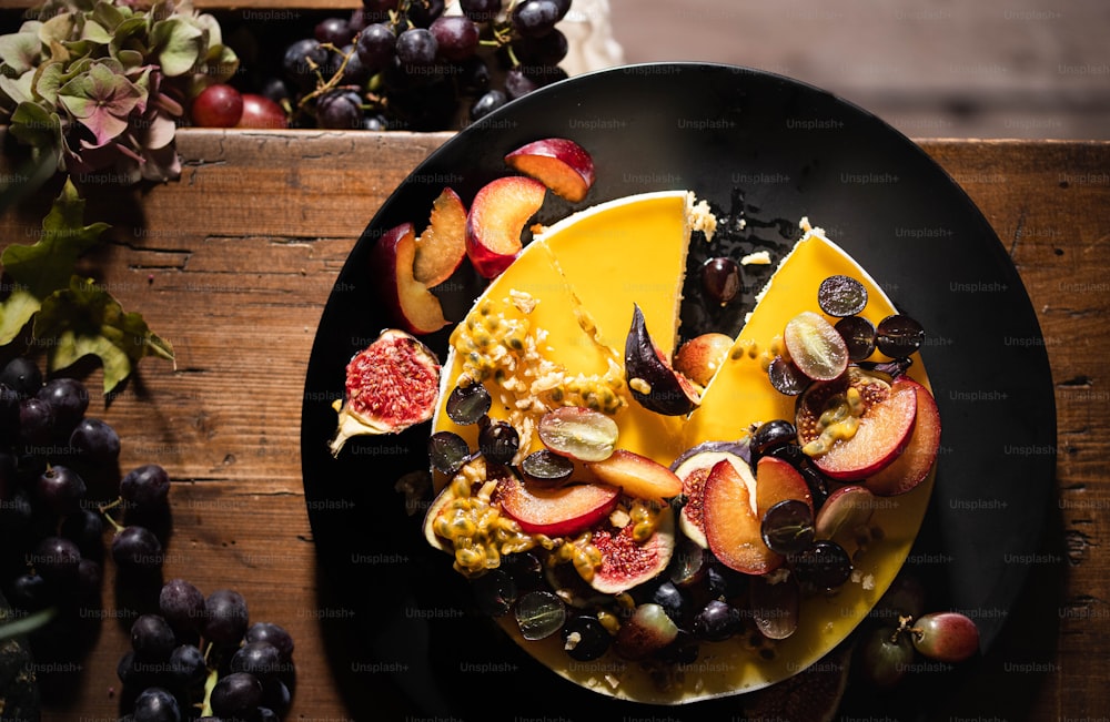 나무 테이블 위에 과일과 치즈 한 접시