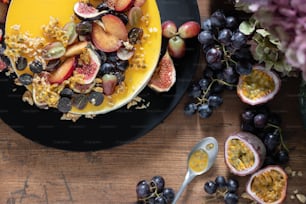 a black plate topped with fruit and cereal