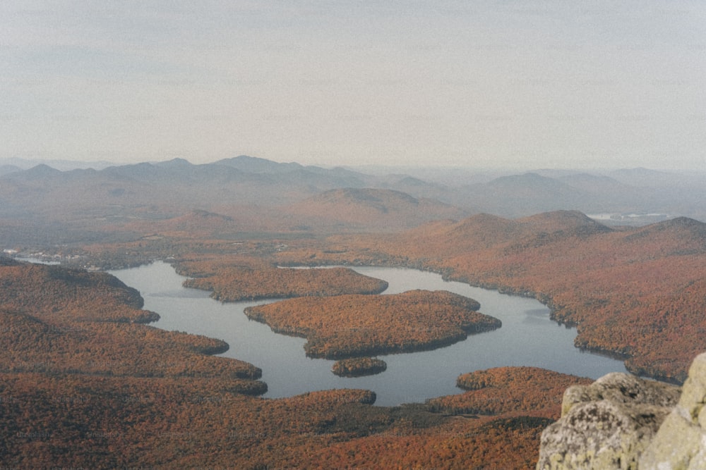 a person sitting on a rock overlooking a lake