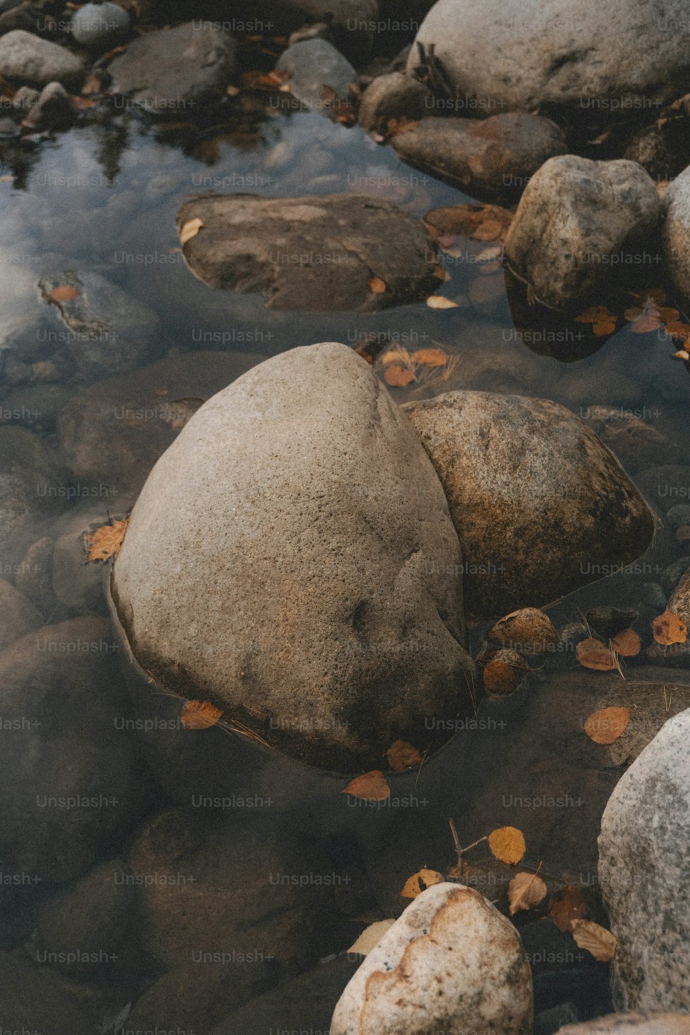 a rock in a body of water surrounded by rocks