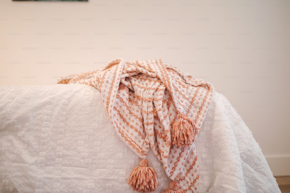 a white bed topped with a white comforter covered in a blanket