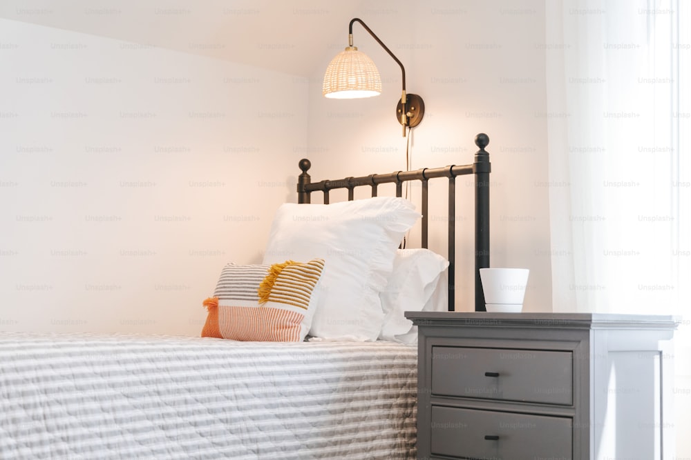 a bedroom with a bed, nightstand, and lamp