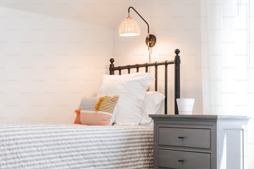 une chambre avec un lit, une table de chevet et une lampe