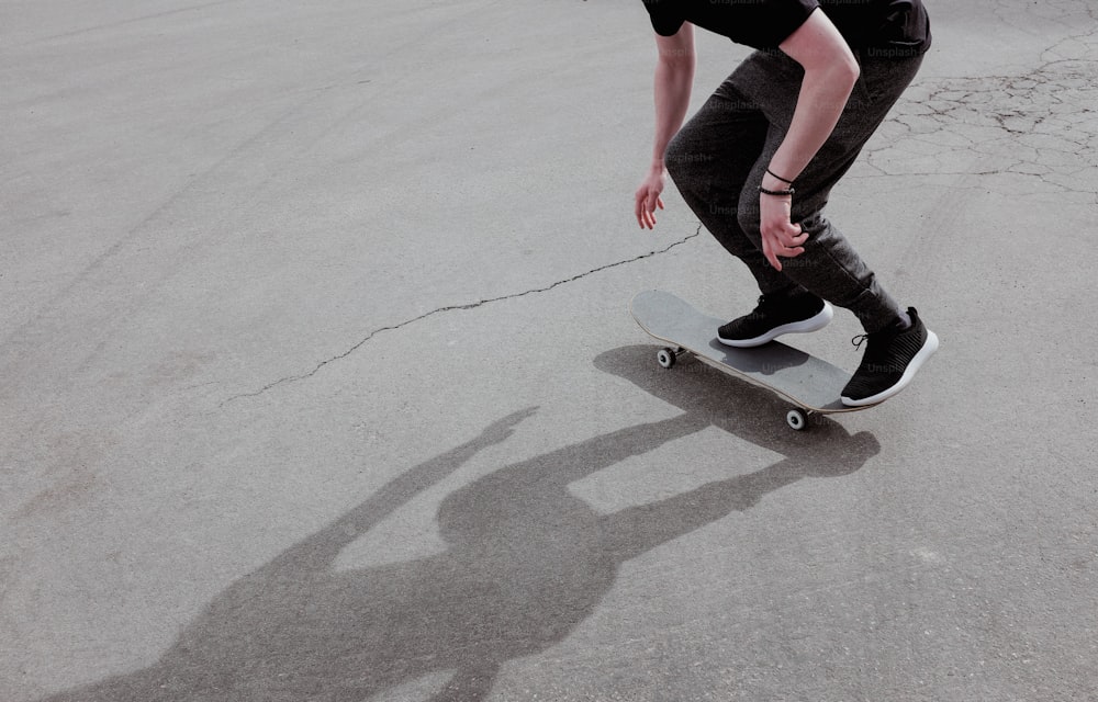 Un uomo che cavalca uno skateboard lungo una strada