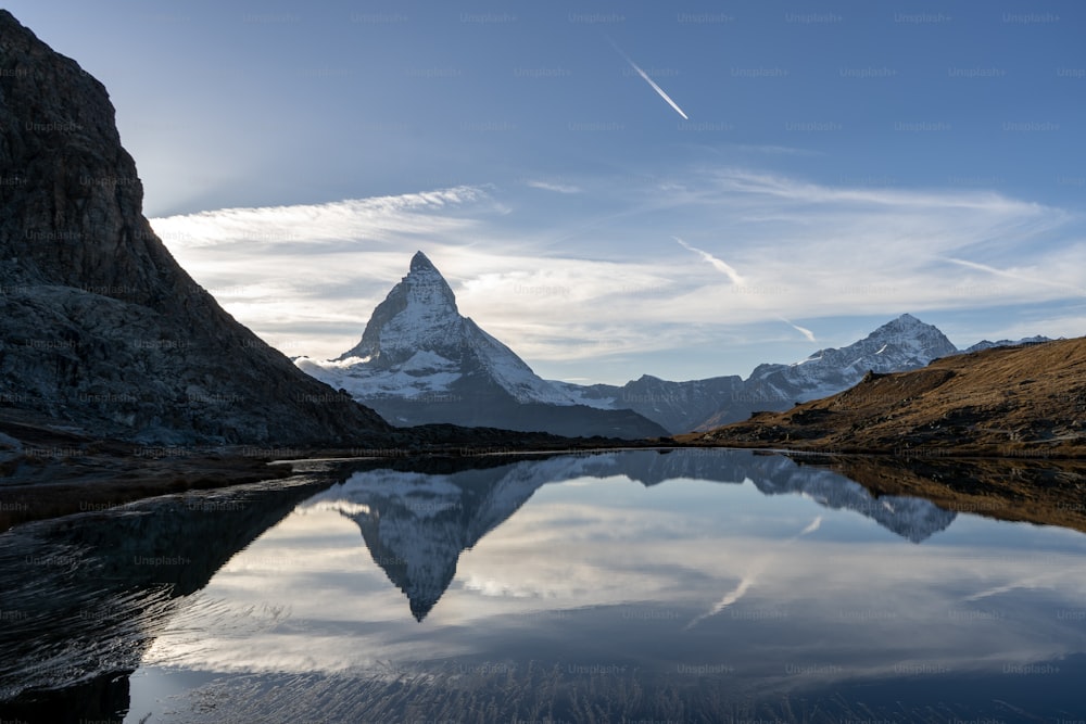 Une montagne se reflète dans l’eau calme d’un lac