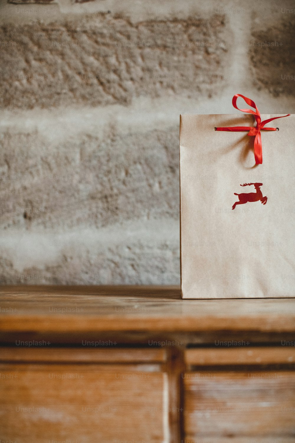 a brown paper bag with a red ribbon tied around it
