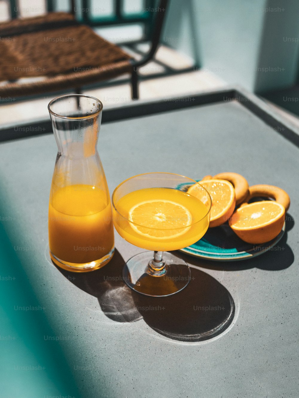 a glass of orange juice next to sliced oranges