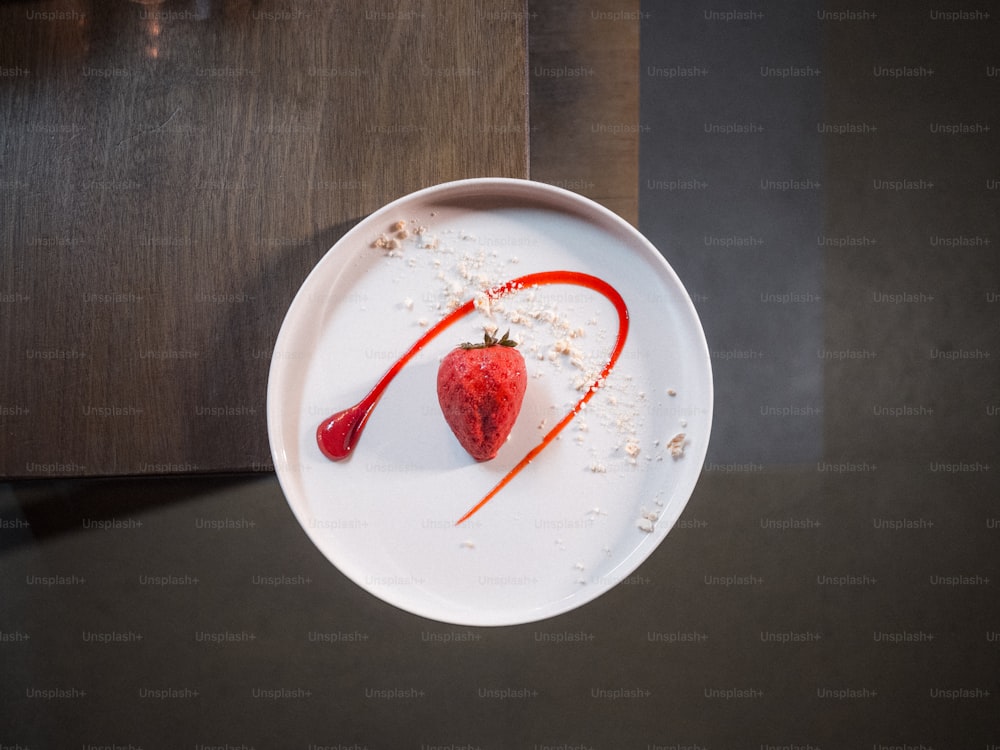 a white plate topped with a strawberry covered in sugar